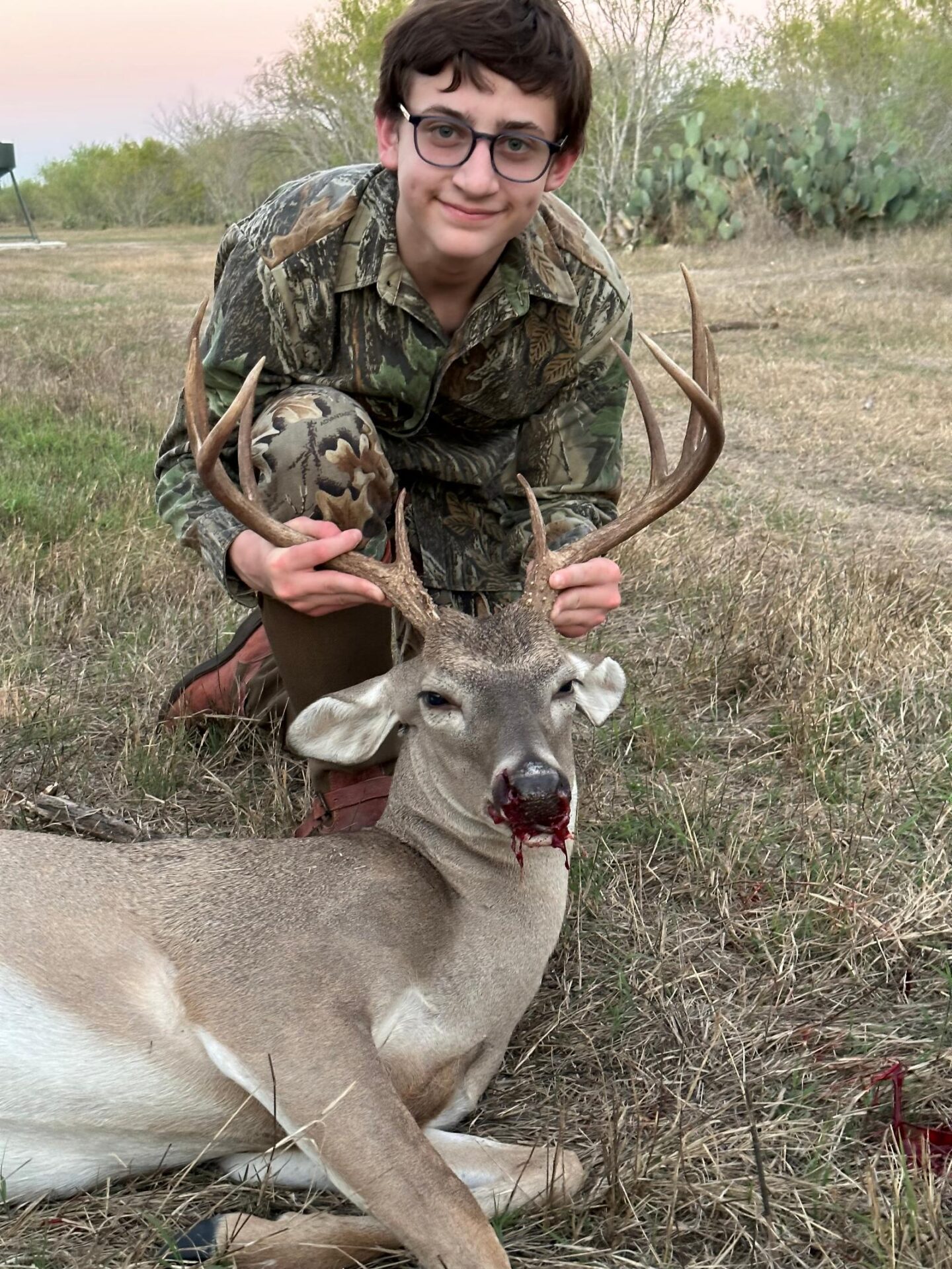 man posing with hunted buck