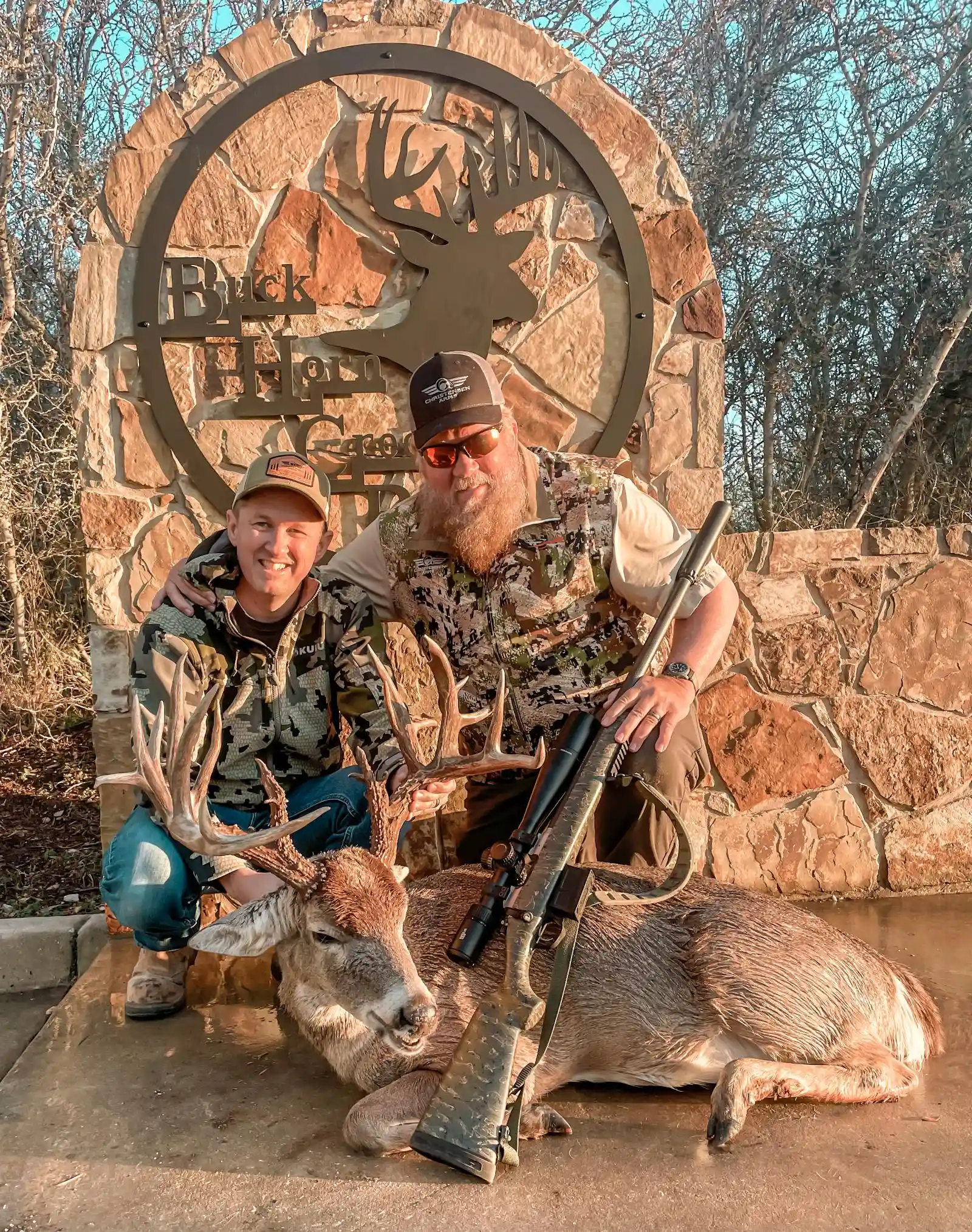Man and son posing with hunted buck