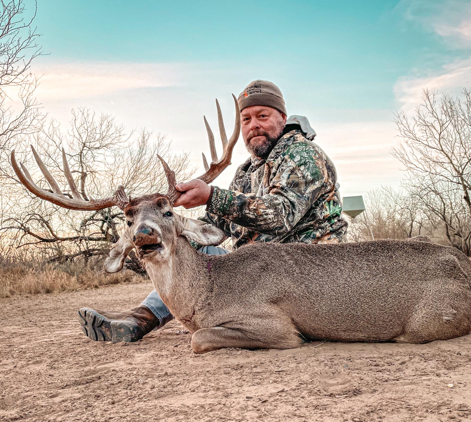 Man posing with hunted buck