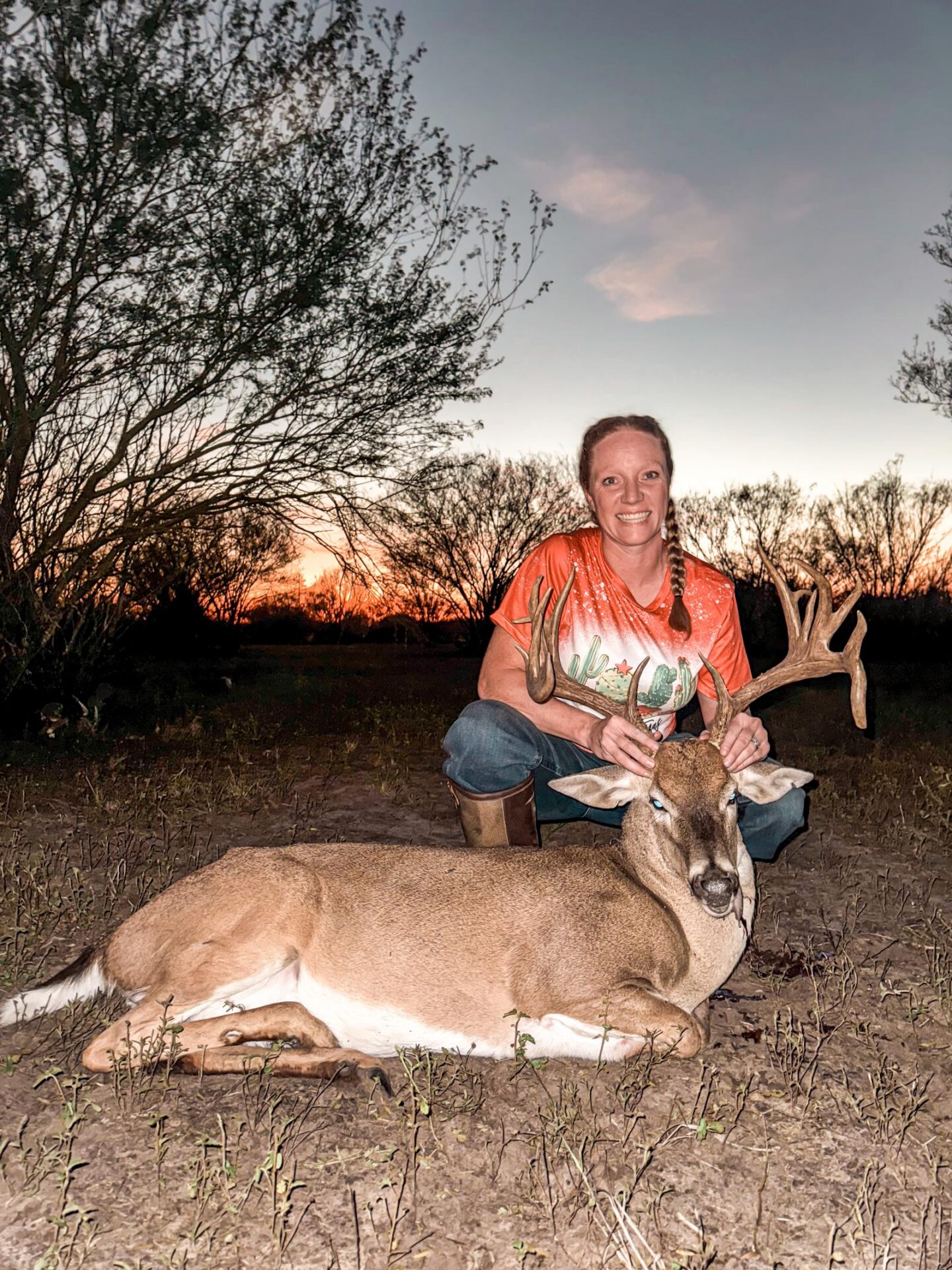 woman posing with hunted buck