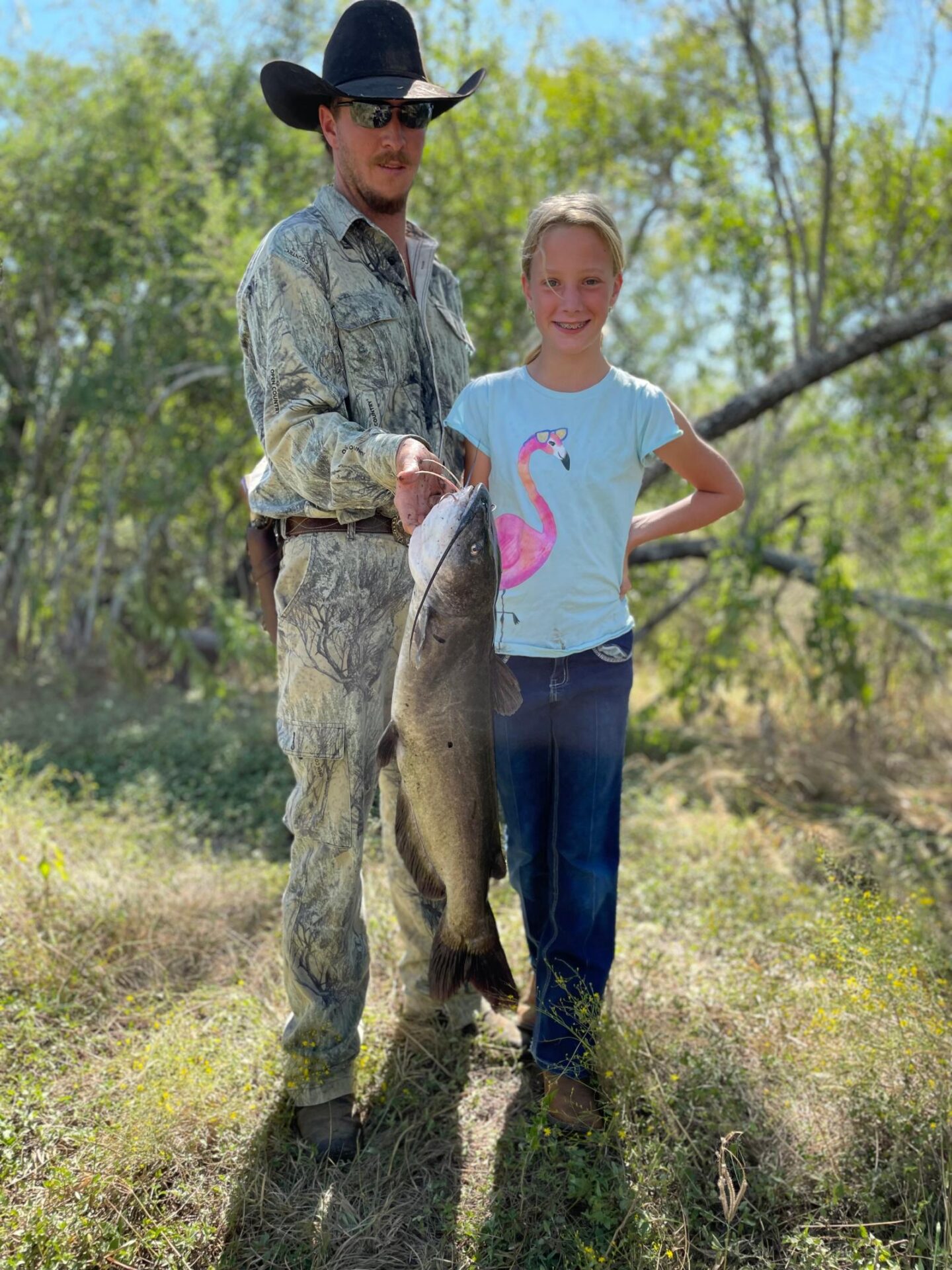 Man and daughter posing with large fish caught