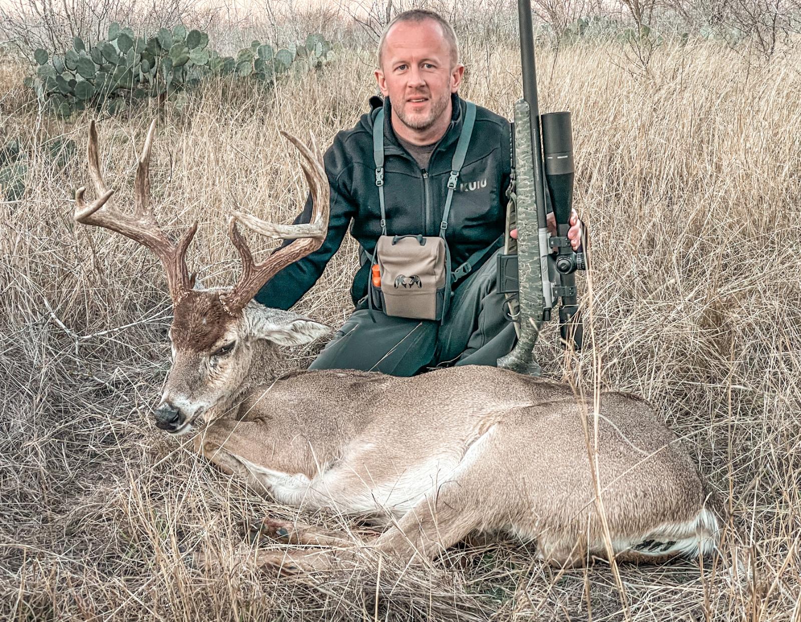 Man posing with hunted buck