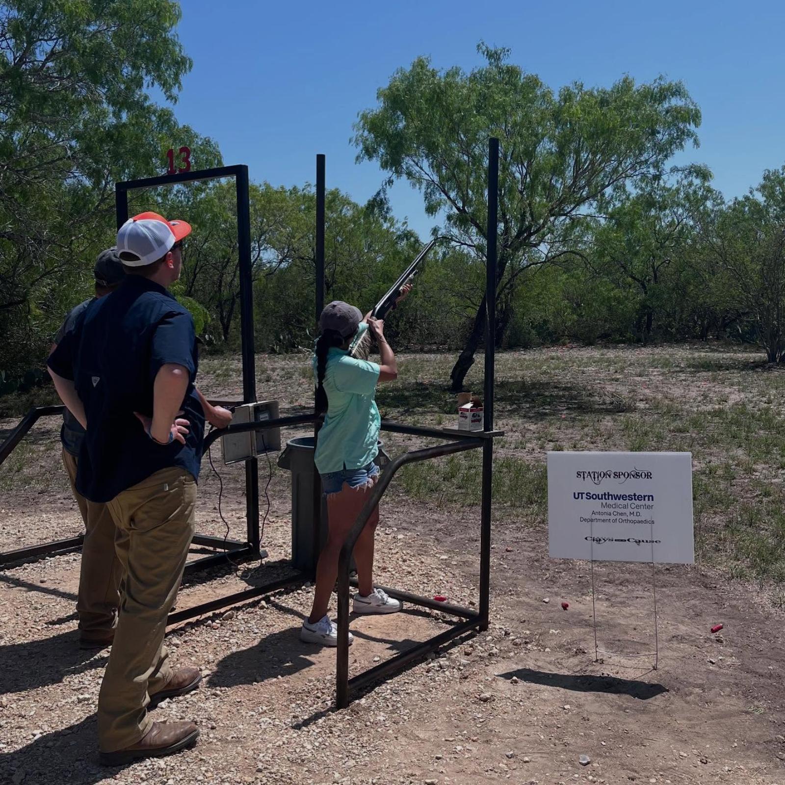 young woman aiming shotgun at sporting clay