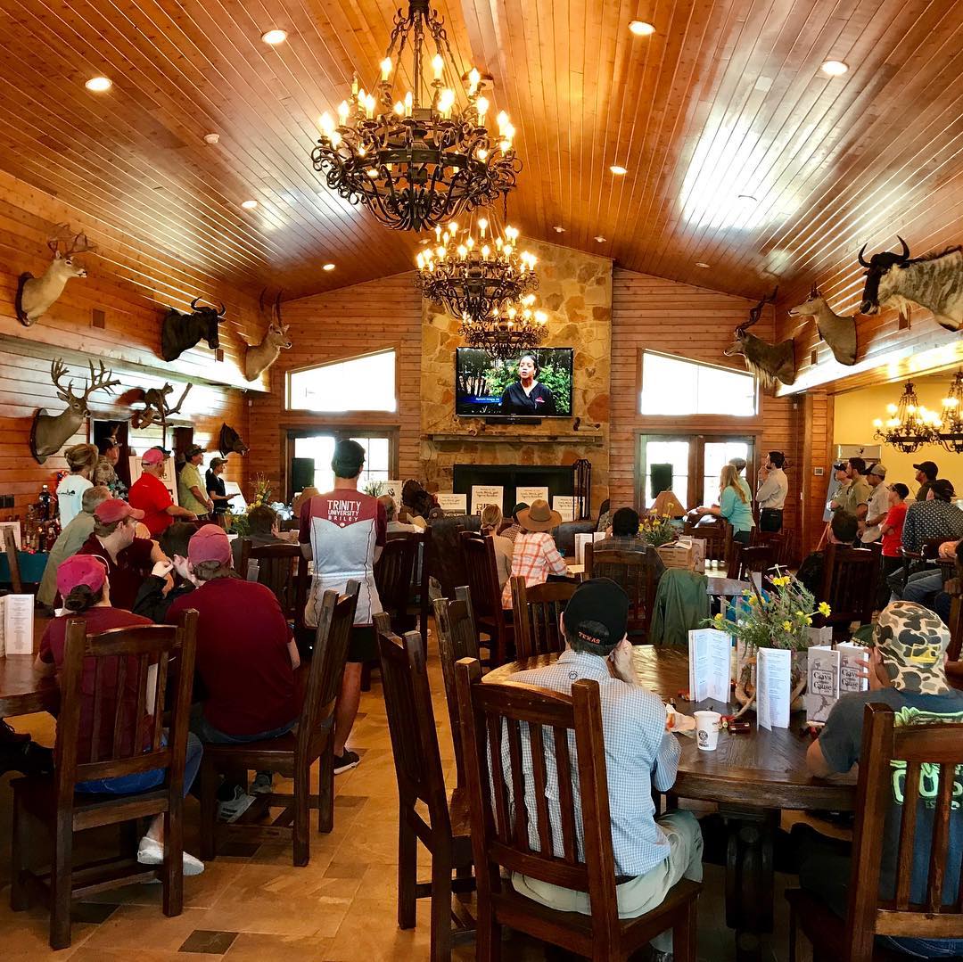 a large group gathers at dining tables inside the lodge